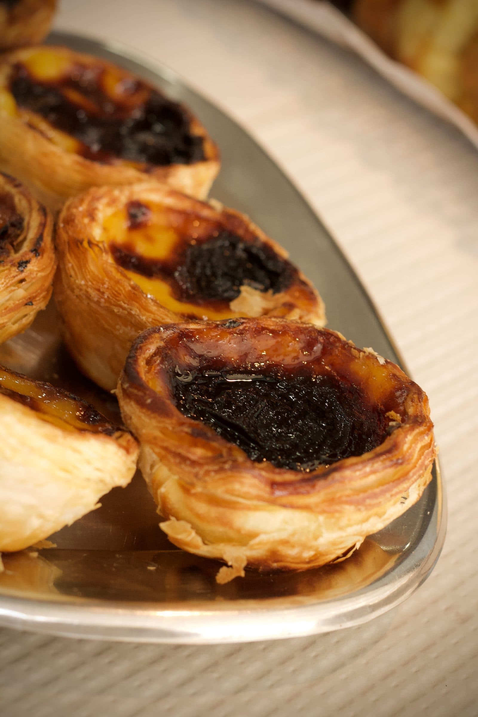 Pastéis de nata e queijadas num tabuleiro